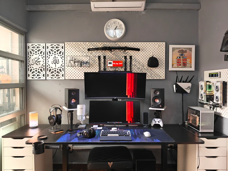 The custom water cooling loop here runs outside the Ncase M2, with two 240mm radiators mounted externally and all EKWB parts throughout. By day the setup handles work, by night it switches to gaming, one keyboard and mouse serving both without any fuss.