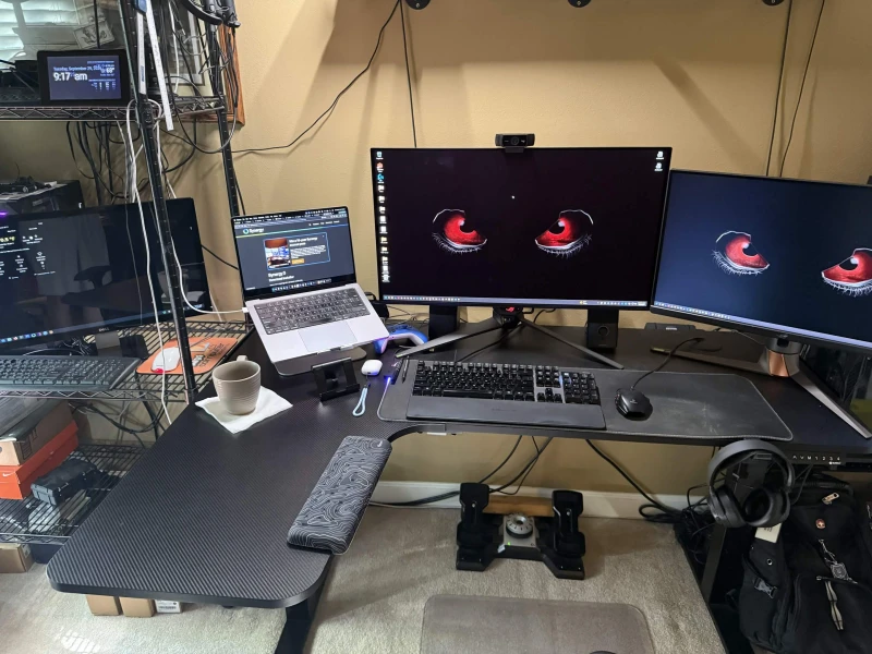 Three machines across three operating systems, all controlled from one keyboard and mouse. The Windows desktop brings serious gaming hardware, the MacBook Pro handles its own workload, and an Ubuntu machine runs alongside them. A Raspberry Pi weather station rounds out the desk.