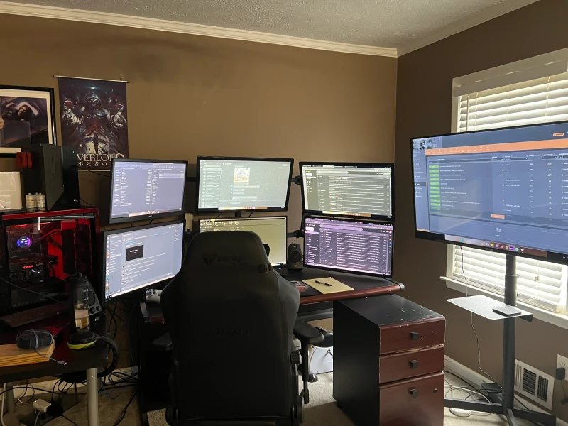 Daily work runs on the lower three displays while the upper screens plus a 50-inch TV handle gaming and everything else, all across two custom-built PCs. Synergy ties both machines to one keyboard and mouse, so moving between work tasks and gaming is just a cursor slide away.