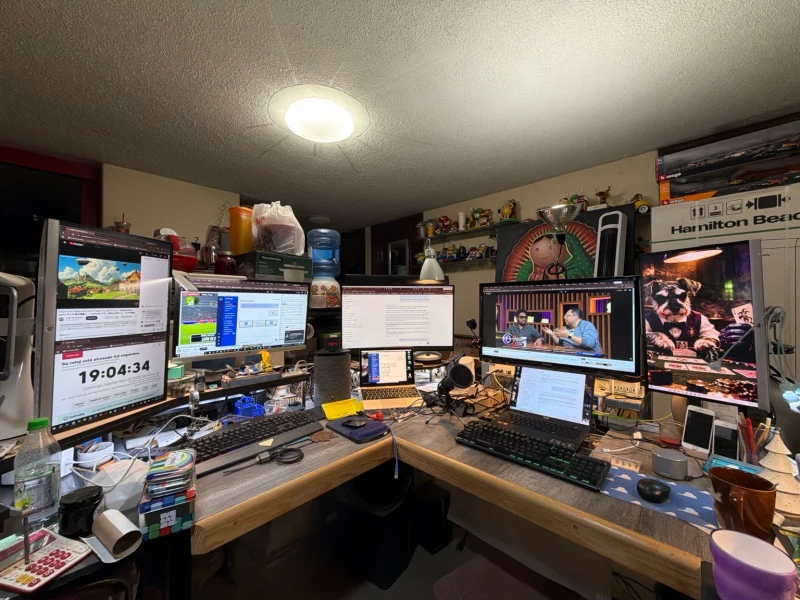 Graphic design, large-format printing, web development, programming, remote support, and business administration all run through this one L-shaped desk every day.