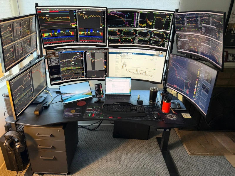 Live trading charts spread across three separate machines, with Synergy keeping one keyboard and mouse shared between them.