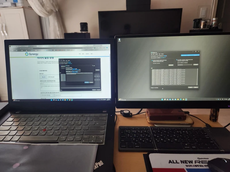 Synergy is mid-connection in this shot, linking a ThinkPad T480 laptop to a ThinkCentre desktop so one keyboard and mouse reach both. The Korean-language setup guide is open on the laptop, walking through the configuration step by step.