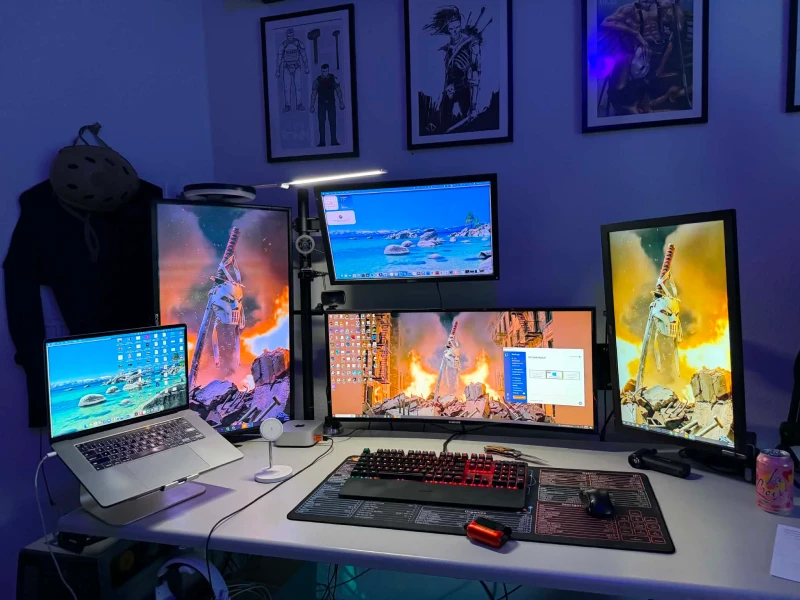 Stretching a tight budget across three computers and five displays, this setup leans on thrift store and garage sale finds: a $12 Samsung ultrawide from Goodwill and a secondhand Dell 24" for the Mac Mini up top. Synergy ties the MacBook Pro and both desktops together with one keyboard and mouse.