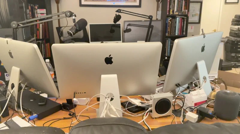 Podcast production, DMX lighting control, and audio work all share the same desk here, spread across multiple Macs tied together by Synergy. With two Deity mics, a Chroma Q Vista EX console, and a VSHOW DMX Node in the mix, one keyboard and mouse reaches everything without switching inputs.